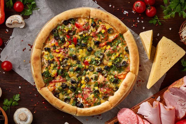 Pizza natürmort. Taze pişmiş pizza ve bileşenlerinin ahşap arka plan üzerine düzenlenmiş bir parçası.