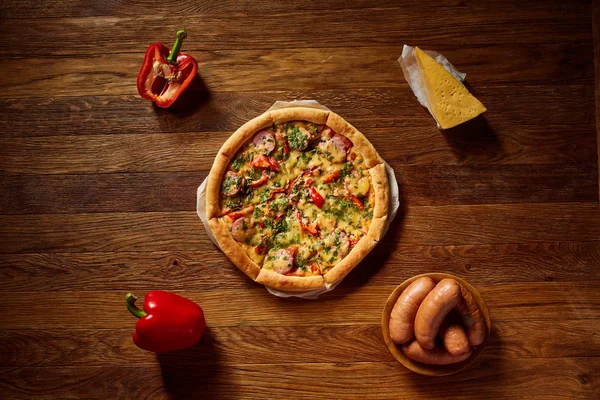 Pizza natürmort. Taze pişmiş pizza ve bileşenlerinin ahşap arka plan üzerine düzenlenmiş bir parçası.