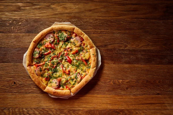 Taze pişmiş pizza dilimleri rustik ahşap arka plan, üstten görünüm, yakın çekim, seçici odak üzerinde bölünmüş.