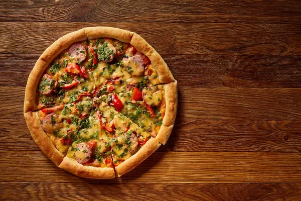 Taze pişmiş pizza dilimleri rustik ahşap arka plan, üstten görünüm, yakın çekim, seçici odak üzerinde bölünmüş.