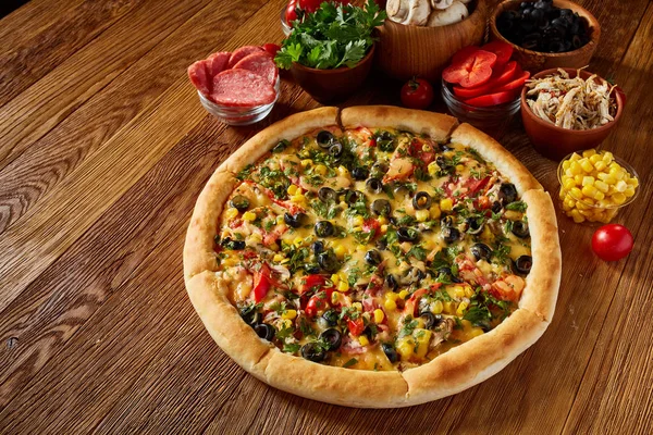 Pizza natürmort. Taze pişmiş İtalyan pizza ve bileşenlerinin düzenlenmiş ahşap arka plan, üstten görünüm, yakın çekim, seçici odak parçası. Lezzetli Aperatif. Geleneksel ev yapımı İtalyan pizza