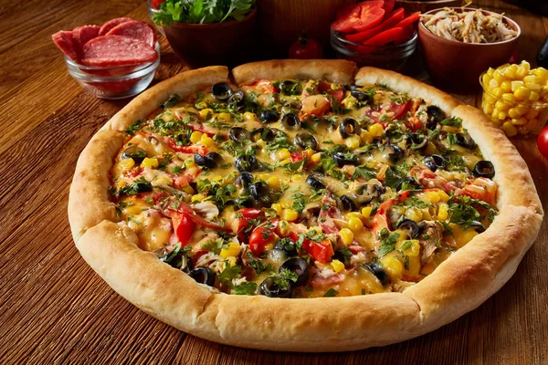 Pizza natürmort. Taze pişmiş pizza ve bileşenlerinin ahşap arka plan üzerine düzenlenmiş bir parçası.