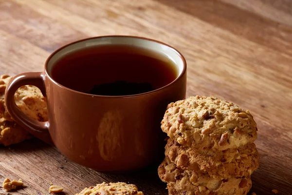 Ahşap ahşap arka plan, üstten görünüm, seçici odak parçası üzerinde çay ve tatlı kurabiye beyaz porselen kupa