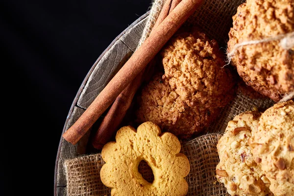 Kavramsal kompozisyon tanımlama bilgileri ürün yelpazesine tarçın grup ve çuval bezi peçete ile kurutulmuş portakal ahşap bir varil üzerinde sopa rustik arka plan, seçici odak, yakın çekim üzerinde. Lezzetli tedavi