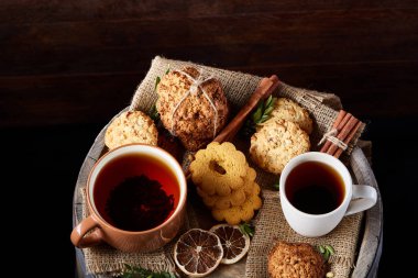 Tarçın ve iki bardak çay bir çuval bezi peçete, seçici odak, yakın çekim, üstten görünüm ile tatlılar.