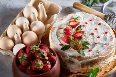 Çilekli tart beyaz arka plan üzerinde düz yatıyordu organik maddeler tarafından çevrili ekşi krem şanti ile kaplı.