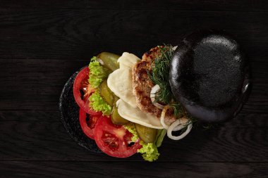 Antika ahşap arka plan, üstten görünüm, yakın çekim, seçici odak siyah burger.