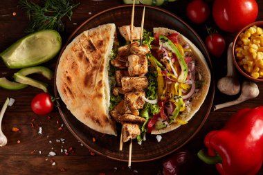 Ahşap arka plan, seçici odak üzerinde Kebap Pide, taze sebze ile egzotik hala slife.