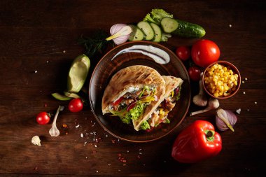 Ahşap arka plan, seçici odak üzerinde Kebap Pide, taze sebze ile egzotik hala slife.