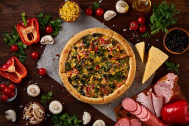 Pizza natürmort. Fırından yeni çıkmış pizza ve ahşap zemin üzerine düzenlenmiş bileşenleri.