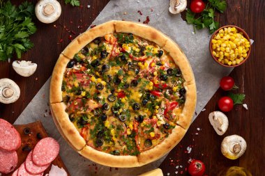 Pizza natürmort. Fırından yeni çıkmış pizza ve ahşap zemin üzerine düzenlenmiş bileşenleri.