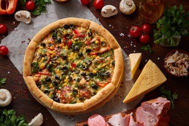 Pizza natürmort. Fırından yeni çıkmış pizza ve ahşap zemin üzerine düzenlenmiş bileşenleri.