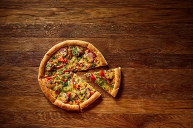 Taze pişmiş pizza dilimleri rustik ahşap arka plan, üstten görünüm, yakın çekim, seçici odak üzerinde bölünmüş.