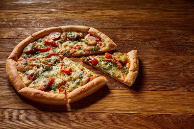 Taze pişmiş pizza dilimleri rustik ahşap arka plan, üstten görünüm, yakın çekim, seçici odak üzerinde bölünmüş.