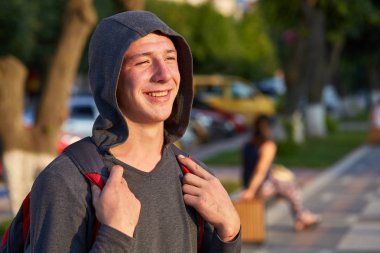 Yaz şehirde yürüyüş yaparken eğlenmek sorun deri ile mutlu bir genç erkek.