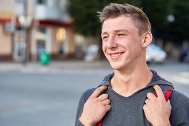 Yaz şehirde yürüyüş yaparken eğlenmek sorun deri ile mutlu bir genç erkek.