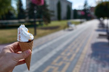 İlk kişi görüntüleyebilir, bir kişi bir dondurma sığ derinlik-in tarla onun elinde olan yol boyunca yürüyüş.