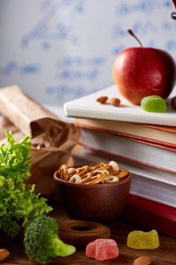 Geri okul kavramı, okul malzemeleri, bisküvi, paket öğle yemeği ve beslenme çantası beyaz yazı tahtası, seçici odak üzerinde.