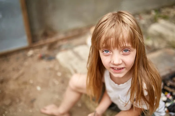 Portrait of tense vulnerable little girl in dirty alley, shallow depth of field. — Stock Photo, Image