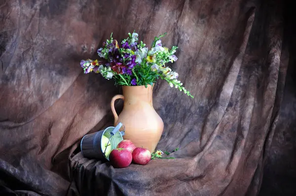 Taze kırmızı ve beyaz çiçekler bir sürahi kil ve bir demet taze kırmızı üzüm. durgun hayat.