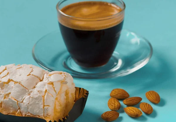 Bir bardak sade kahve, kremalı kek ve bademli.