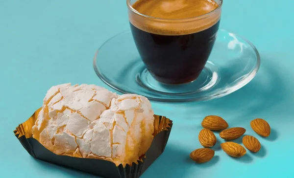 Bir bardak sade kahve, kremalı kek ve bademli.