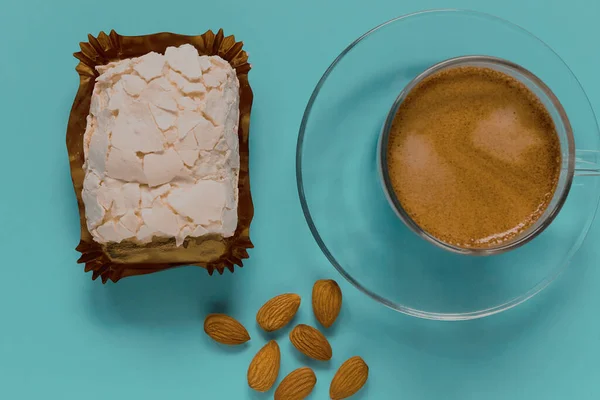 Kremalı kek ve bademli bir bardak sade kahve. Üst görünüm.