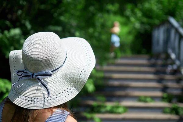 Merdivenlerin arkasında şapkalı bir kız.