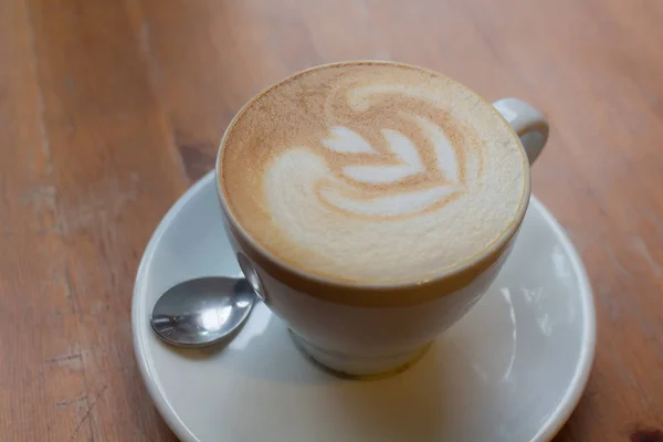 Hot late art in white cup on table,