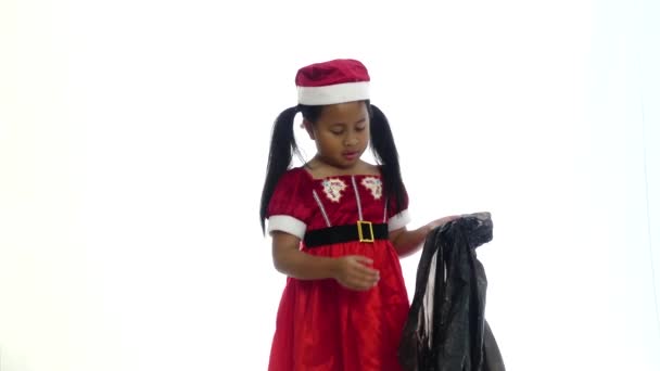 亚洲人可爱的女孩穿着圣诞老人西装与持有礼品盒由黑色袋 — 图库视频影像
