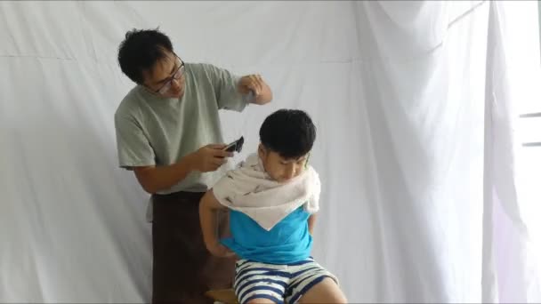 白い背景の時間経過ビデオ 上の息子の髪をカットする父 — ストック動画