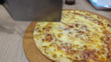 Pizza masanın üstünde ki tahta tepside..