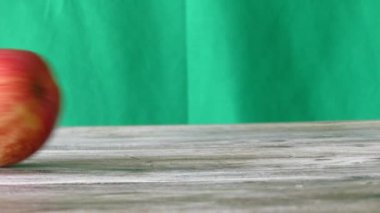 Elma ahşap bir masa ve yeşil arka plan üzerine haddelenmiş,