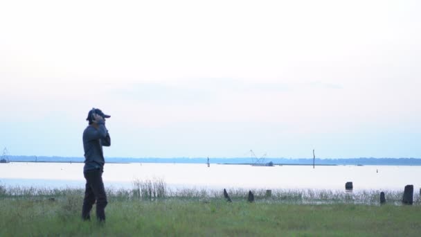 Genç Erkekler Kulaklık Takıp Gölün Arka Planında Dans Ederek Telefondan — Stok video