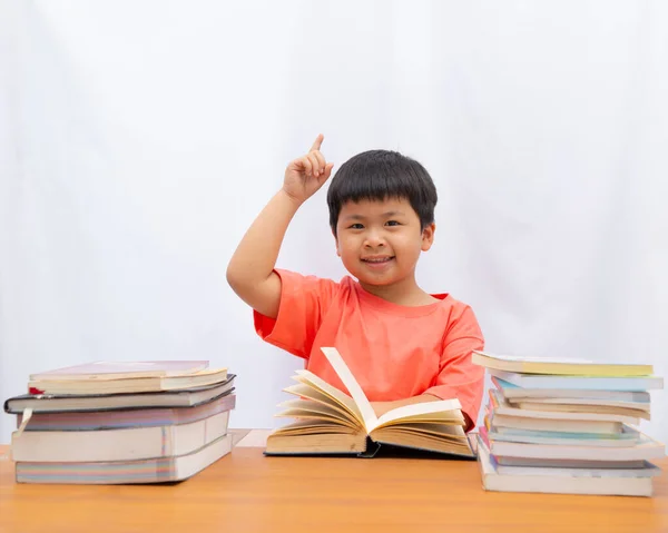 Asiático lindo un pequeño niño leyendo con dedo celebración en blanco bac —  Fotos de Stock