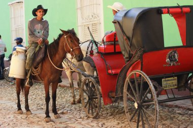 Atlar ve stetson, Küba Trinidad, 16.12.2018 beygir ve Küba sokaklarında çalkantılı süt dağıtan sütçülerden nefret ediyordu. Kırmızı atlı adamla konuşuyorlardı. Yüksek kalite fotoğraf