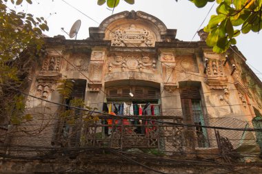 Hanoi, Vietnam 20.12.2013 Old Quarter 'ın geçmişinden kalma birçok sömürge binası vardır. Genellikle tamir edilemez durumdadır. Balkondan sarkan ve çatıdaki uydu çanağından sarkan. Yüksek kalite fotoğraf