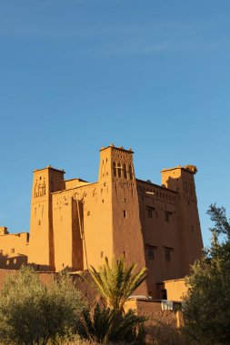 Citadel Ait Ben Haddou ksar Fas, Unesco Miras 'ın antik kalesi. Ballı güzel bir öğleden sonra ışığı, altın renkli çamur tuğlalı yapı bulutlu mavi bir sineğe karşı 