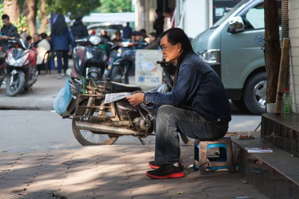 Hanoi Vietnam 20.12.2013 Sabahın erken saatlerinde sokakta gazete okuyan adam — Stok fotoğraf
