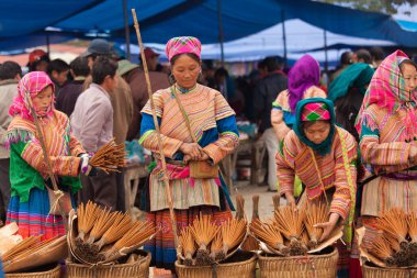 Bac Ha Market Vietnam 12.22.2013 Çiçek Hmong kadın grubu tütsü satıyor.