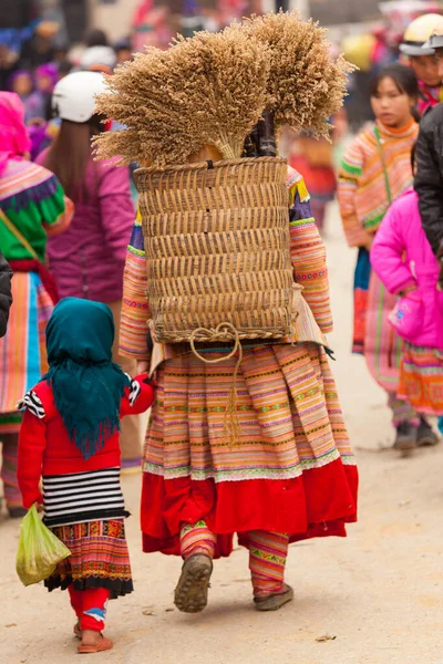 Bac Ha Market Vietnam 12.22.2013 Mujer y niño de la espalda, llevando hierbas — Foto de Stock