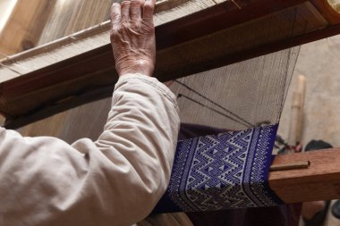 Phonsavan Laos yakınlarındaki Napia 'yı yasaklayın. Yerel dokumacılar atkı ve battaniye için kumaş yapıyorlar ve Vietnam savaşından kalma bombalardan kaşık yapıyorlar. Yüksek kalite fotoğraf