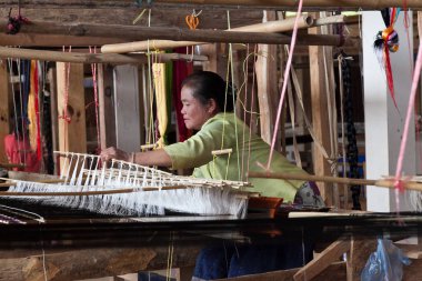 Phonsavan Laos yakınlarındaki Napia 'yı yasaklayın. Yerel dokumacılar atkı ve battaniye için kumaş yapıyorlar ve Vietnam savaşından kalma bombalardan kaşık yapıyorlar. Yüksek kalite fotoğraf