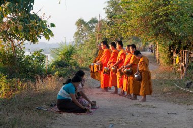 Muong Khong Laos 1.12.2012 Şafak sökerken köyde pirinç toplamak için keşişler
