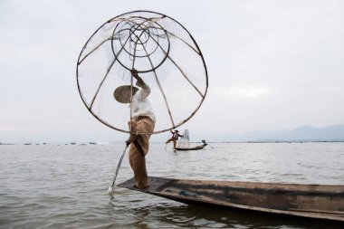 Inle Gölü Myanmar 12.16.2015 Intha balıkçısı geleneksel koni balık ağı kullanıyor