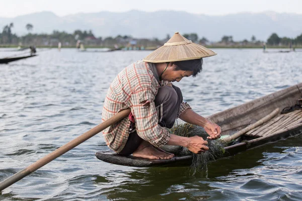 Inle Gölü, Myanmar 12.16.2015 Geleneksel Intha balıkçısı ağlar örüyor