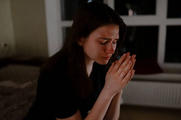 Teenager praying to God at night in apartment — Stock Photo, Image