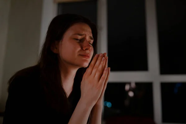 Mujer joven rezando y llorando por la noche — Foto de Stock