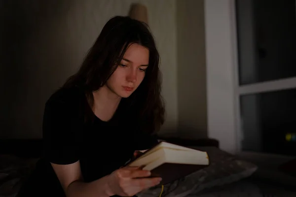 Woman reads the Bible at night