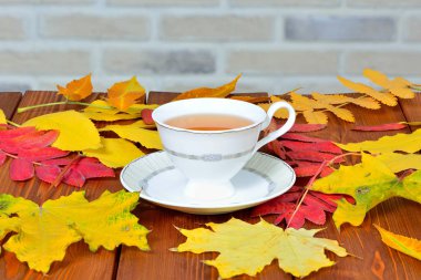 sonbahar yaprakları ile kaplı tabloda çay